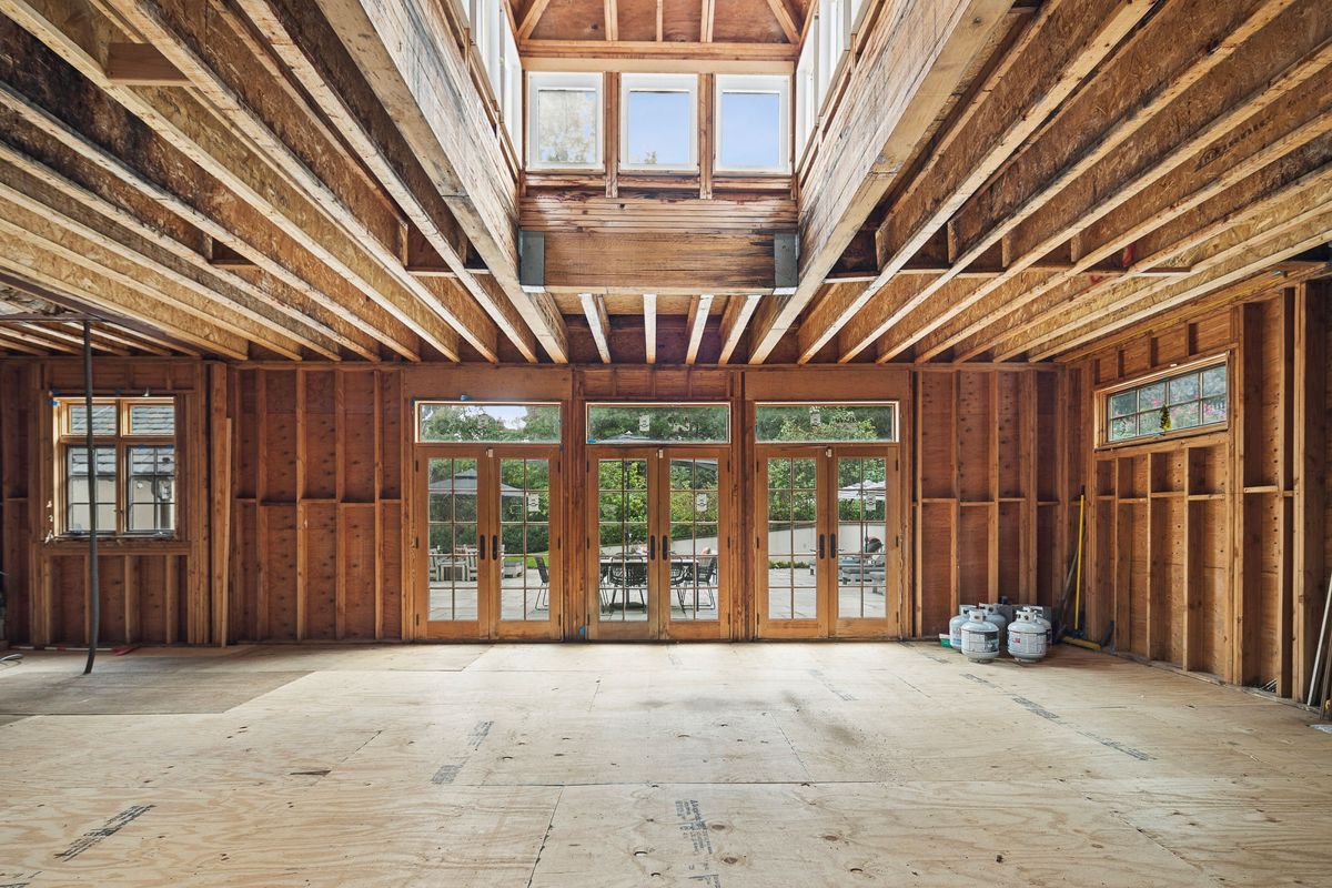 Interior of the unfinished addition showing exposed framing and French doors at 184 Upper Mountain Avenue
