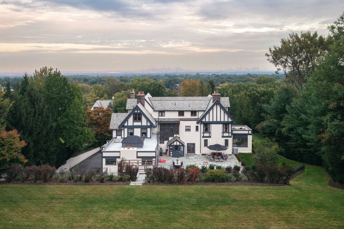 Rear elevation of 184 Upper Mountain Avenue above the lawn at sunset, with the eastern horizon beyond