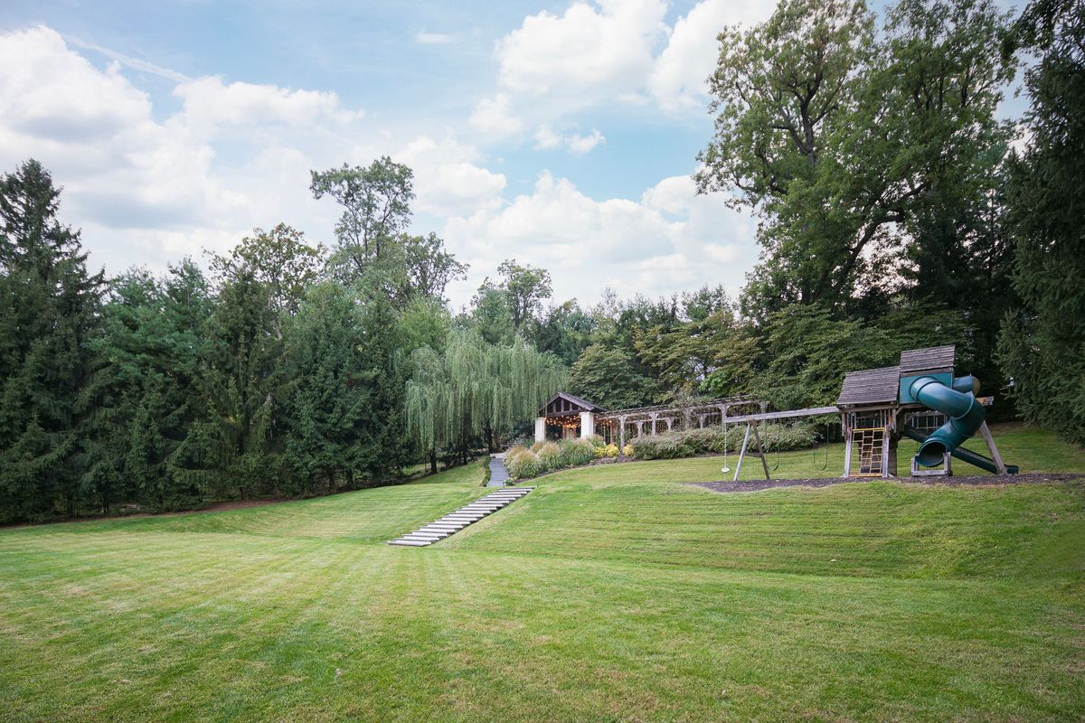 The upper lawn bordered by mature trees at 184 Upper Mountain Avenue